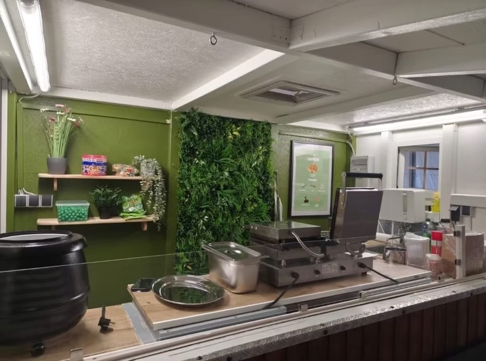 Innenansicht des WuppiePie Crêpeswagens mit Crêpe-Platten und Pflanzenwand